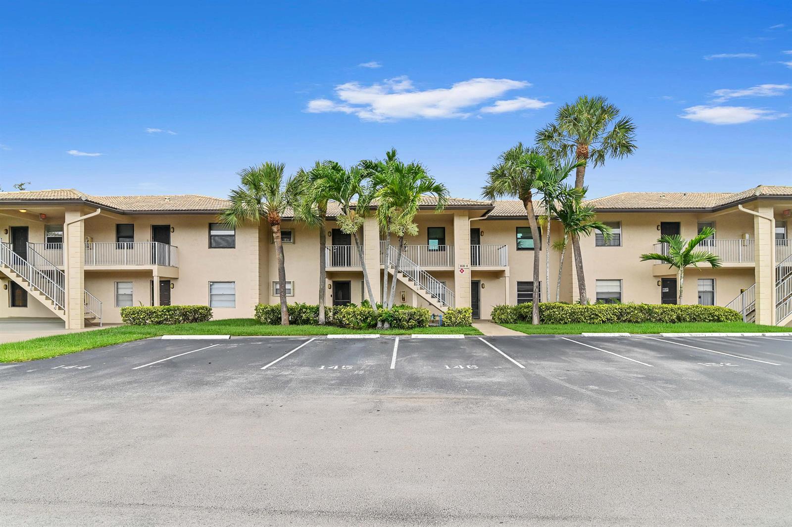 A two-story apartment building with a parking lot in the foreground and palm trees — 5530 Lakeside Drive # 203, Margate FL 33063, MARGATE, FL
