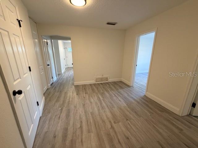 A room with light-colored wood-look flooring, white walls, and doorways leading to other interior spaces — 1310 FAIRVIEW AVENUE, WINTER PARK, FL