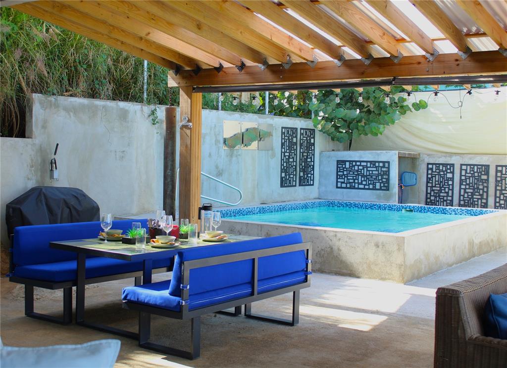An outdoor patio features a dining set, a covered pergola, and a raised swimming pool — 210 VISTA BELLA, VIEQUES, PR