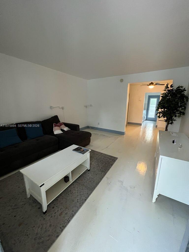 A living room features a dark sectional sofa, a white coffee table, and light flooring — 761 Euclid Ave # 12B, Miami Beach FL 33139, MIAMI BEACH, FL