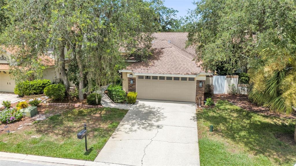 An exterior view of a single-story house with a two-car garage and mature trees — 711 ANDOVER CIRCLE, WINTER SPRINGS, FL