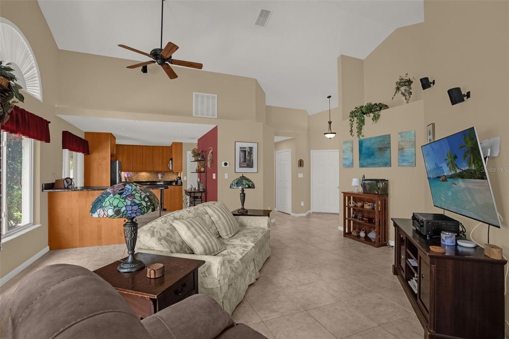 A living room features tile floors, a vaulted ceiling, a ceiling fan, and an open kitchen — 711 ANDOVER CIRCLE, WINTER SPRINGS, FL