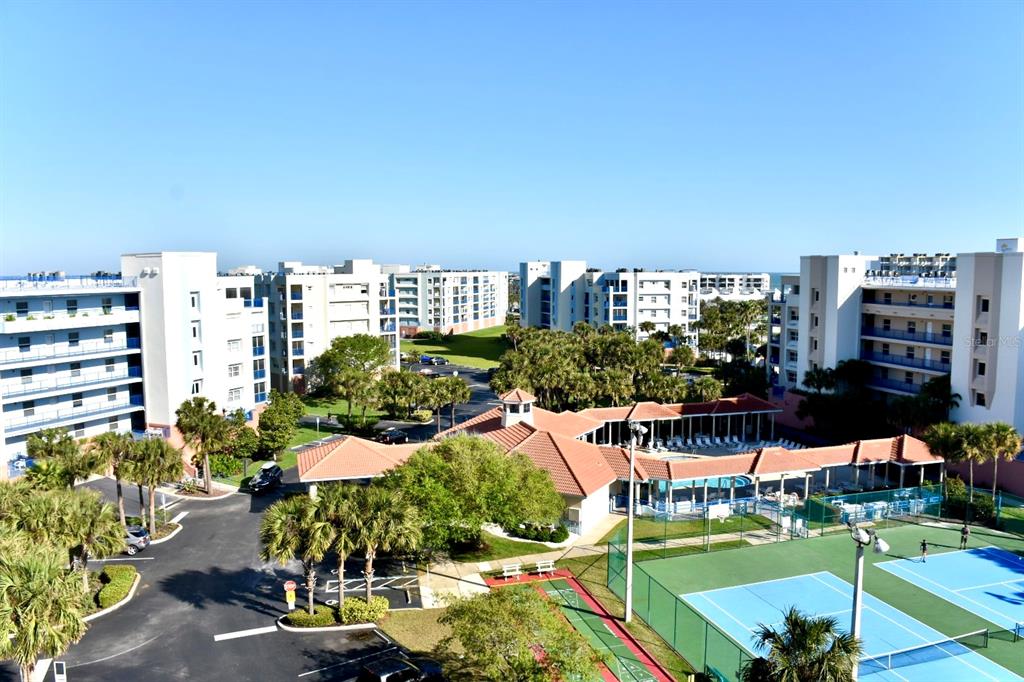 An elevated view of apartment buildings, a swimming pool, and tennis courts — 5300 S ATLANTIC AVENUE UNIT 8-302, NEW SMYRNA BEACH, FL