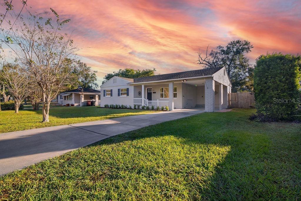 A single-story house with a white exterior, a front porch, and an attached carport — 527 SUNRISE DRIVE, ORLANDO, FL