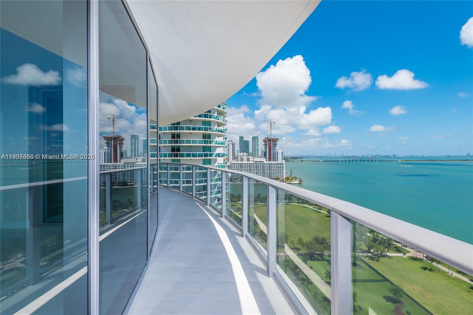 A curved balcony with glass railings overlooks a park, a bay, and city skyscrapers — 488 NE 18th St # 1815, Miami FL 33132, MIAMI, FL