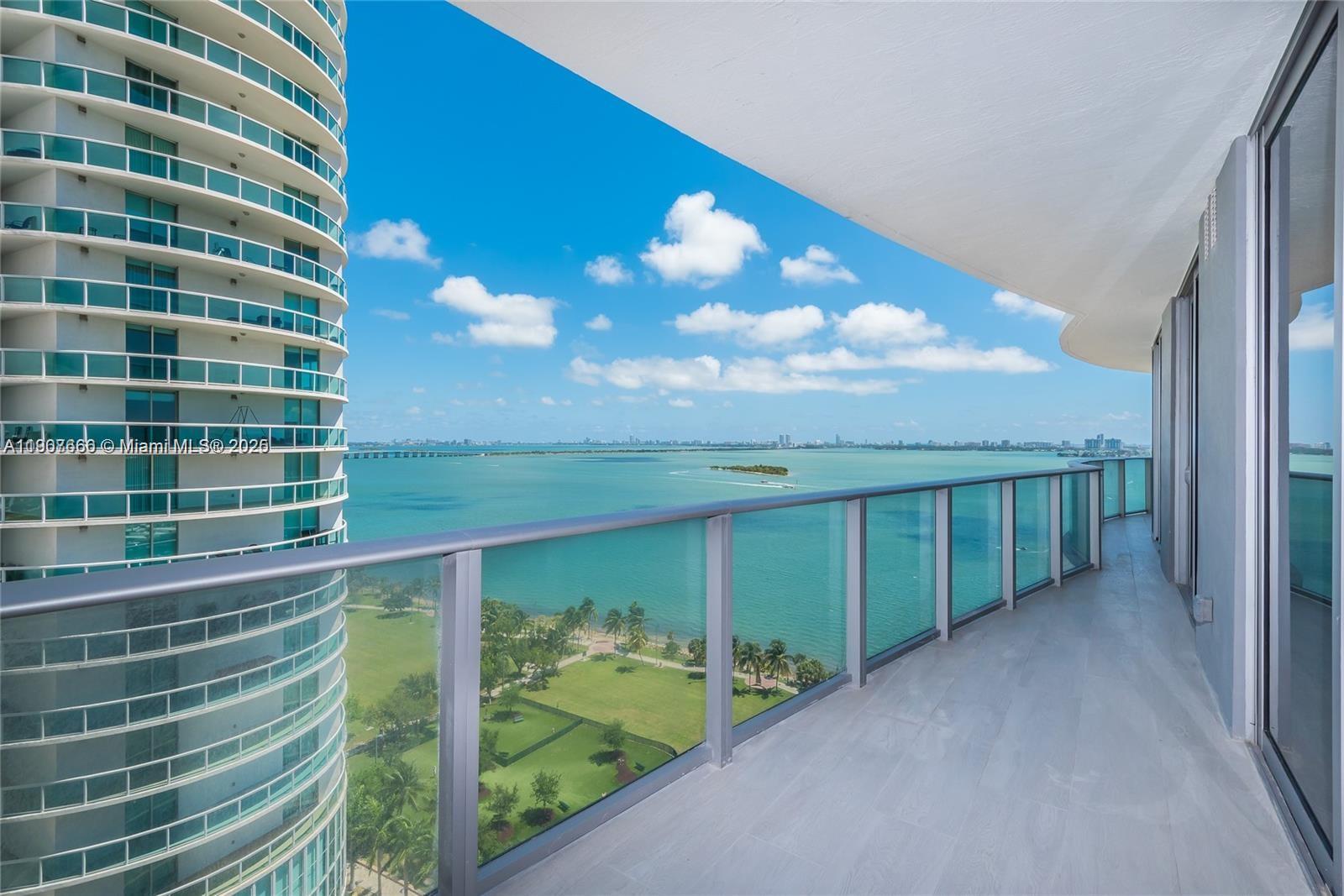 A high-rise balcony overlooks a bay, a park, and a neighboring glass residential tower — 488 NE 18th St # 1815, Miami FL 33132, MIAMI, FL