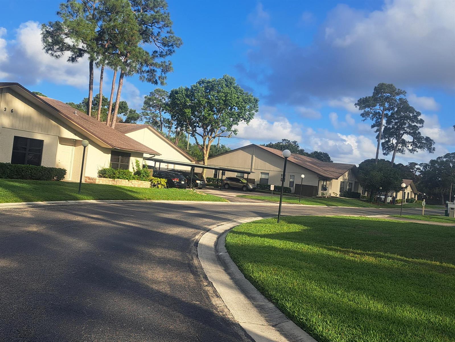 A view of apartment buildings with carports and lawns under a blue sky — 2838 Stoneway Lane, Fort Pierce FL 34982, FORT PIERCE, FL