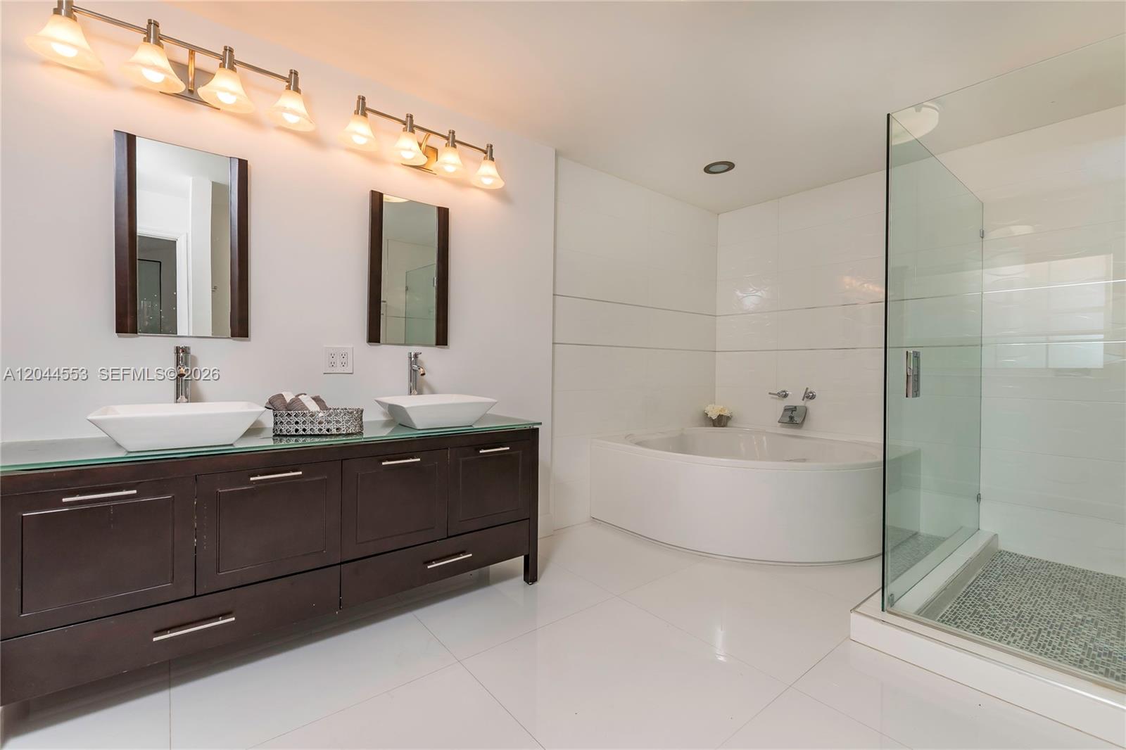 A modern bathroom features a double vanity, a soaking tub, and a glass-enclosed shower — 5132 NW 106th Ave, Doral FL 33178, DORAL, FL