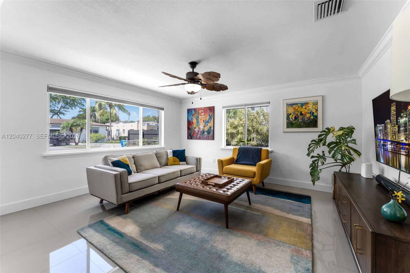 A living room features a grey sofa, yellow armchair, leather ottoman, and a large area rug — 2131 SW 17th St, Miami FL 33145, MIAMI, FL