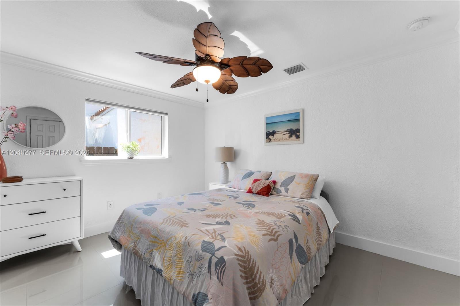 A bedroom features a palm-leaf ceiling fan, white walls, a floral bedspread, and tile flooring — 2131 SW 17th St, Miami FL 33145, MIAMI, FL