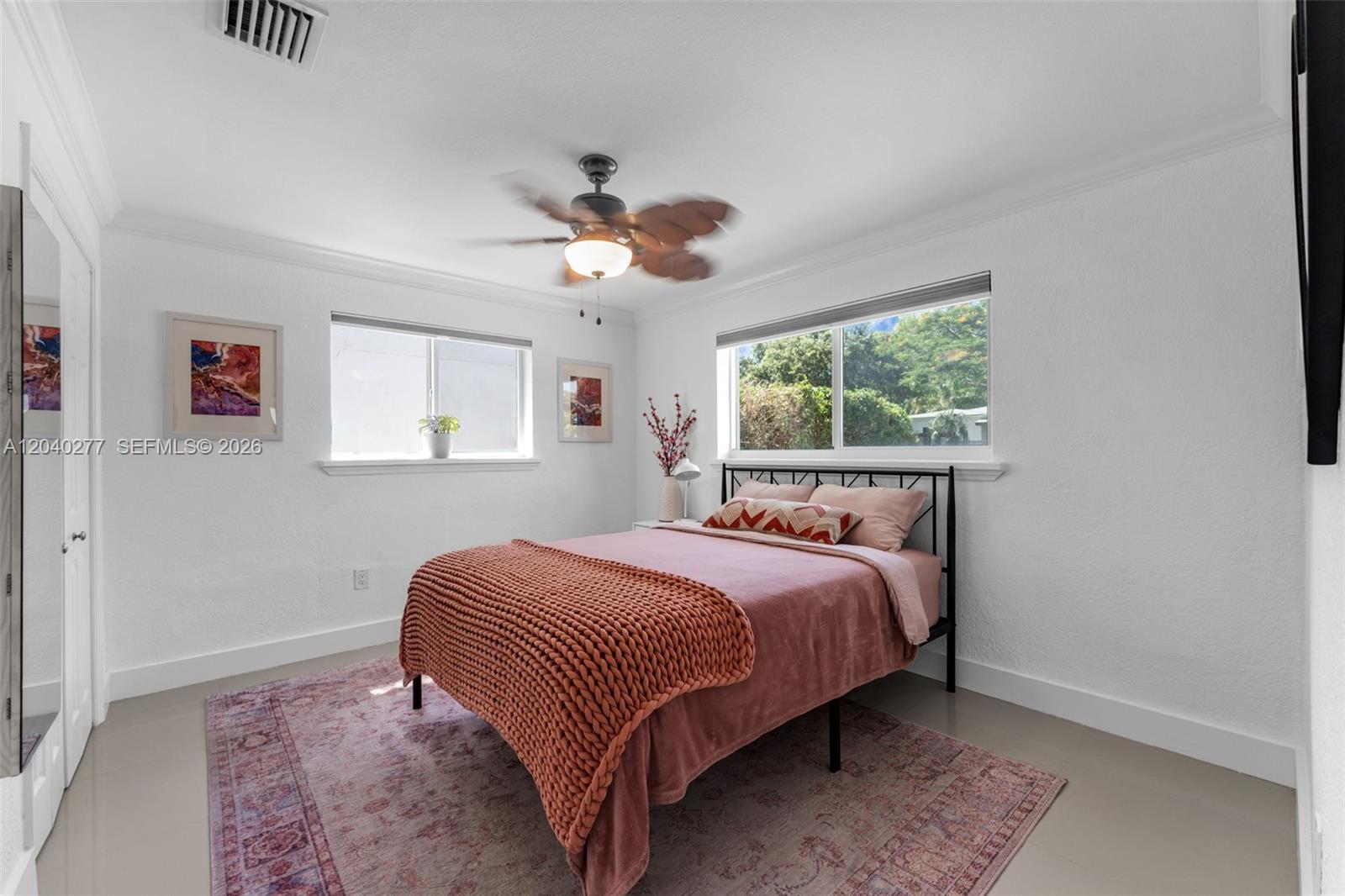 A bedroom features a bed with a pink blanket, a ceiling fan, and two windows — 2131 SW 17th St, Miami FL 33145, MIAMI, FL