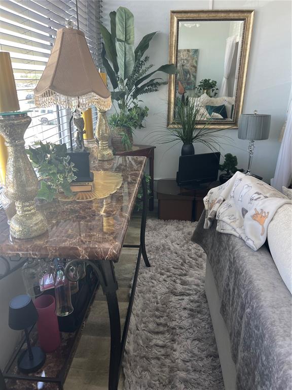 A marble-topped console table sits beside a sofa in a room with a large mirror — 2290 AARON STREET UNIT 207, PORT CHARLOTTE, FL