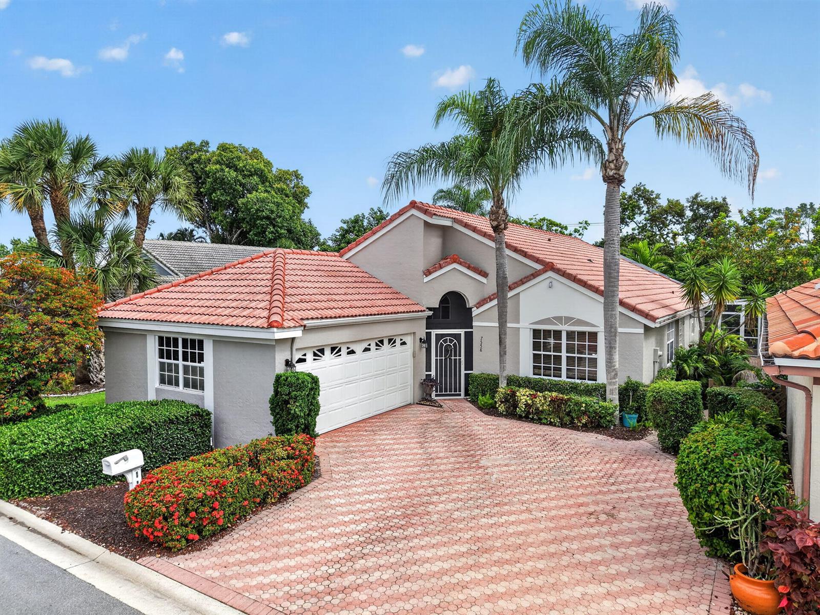 A single-story house with a red tile roof, white garage door, and a paved driveway — 7558 Ironbridge Circle, Delray Beach FL 33446, DELRAY BEACH, FL