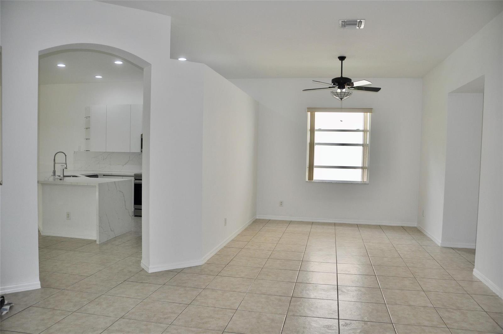 An open-concept dining area with tile flooring and a ceiling fan adjacent to a kitchen — 19496 S Whitewater Avenue, Weston FL 33332, WESTON, FL