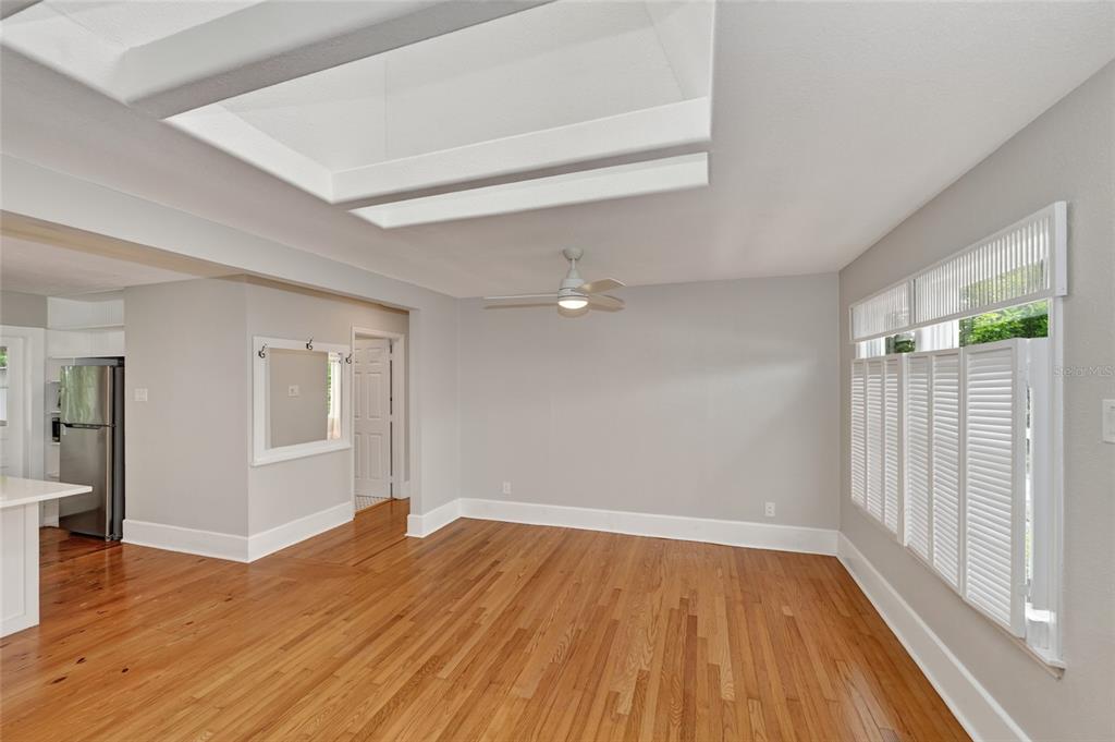 An empty room with hardwood floors, a ceiling fan, and a large rectangular skylight — 1010 VIRGINIA DRIVE, SARASOTA, FL