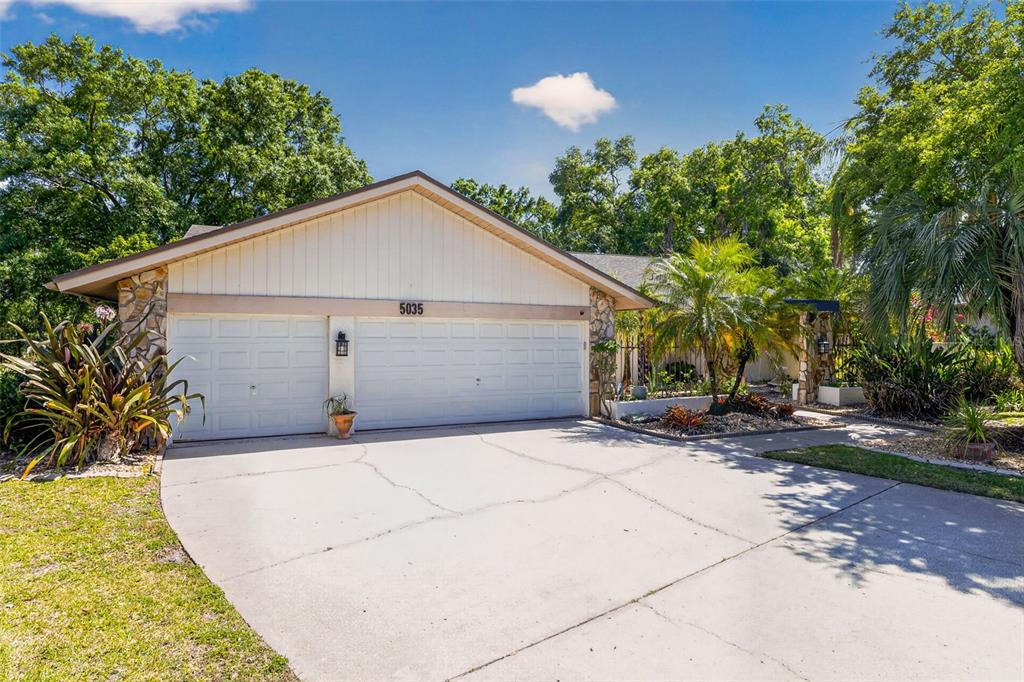 A single-story house with a two-car garage, stone accents, and a concrete driveway — 5035 BARROWE DRIVE, TAMPA, FL