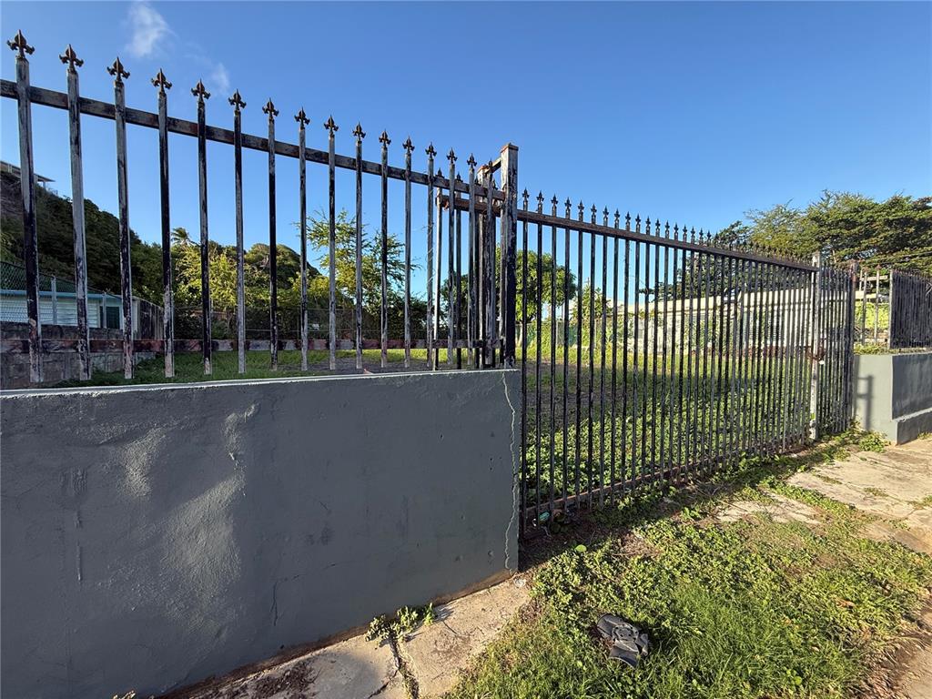 A metal fence with decorative finials stands behind a gray concrete wall on a lot — . UNION UNIT 475, PUERTO REAL, PR