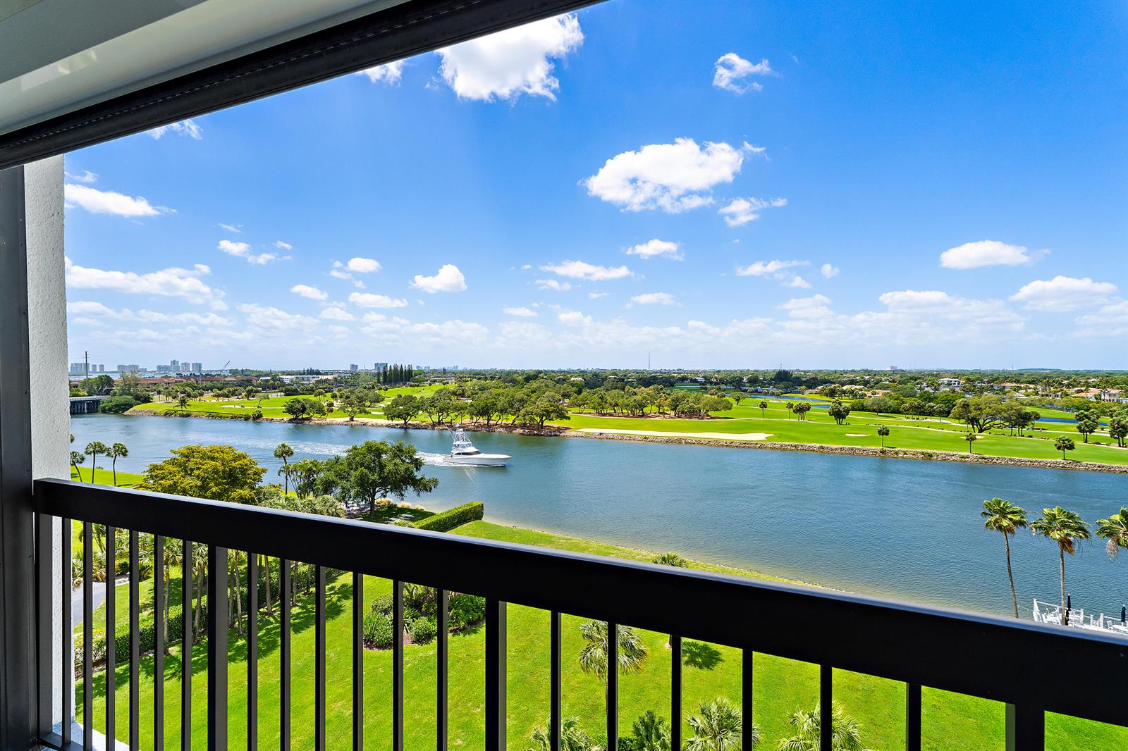 A balcony view overlooks a river, a boat, and a golf course under a blue sky — 356 Golfview Road # 903, North Palm Beach FL 33408, NORTH PALM BEACH, FL