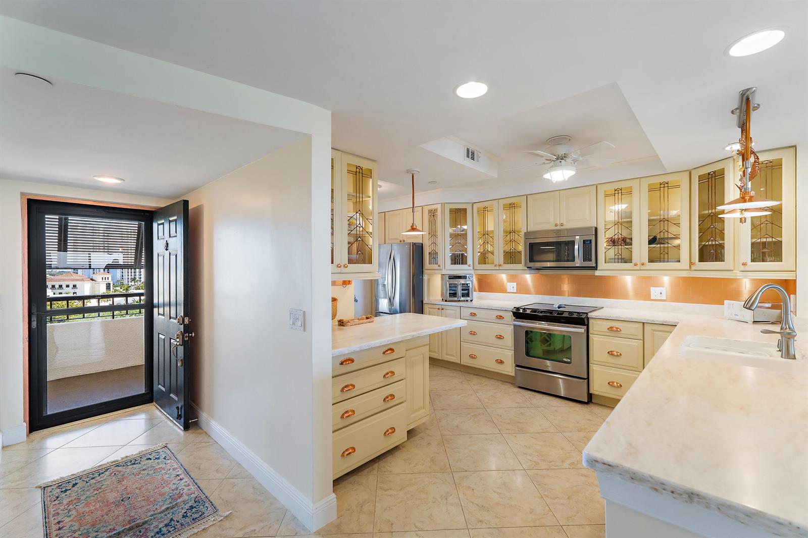 A kitchen features light-colored cabinets, stainless steel appliances, a marble countertop, and an exterior door — 356 Golfview Road # 903, North Palm Beach FL 33408, NORTH PALM BEACH, FL