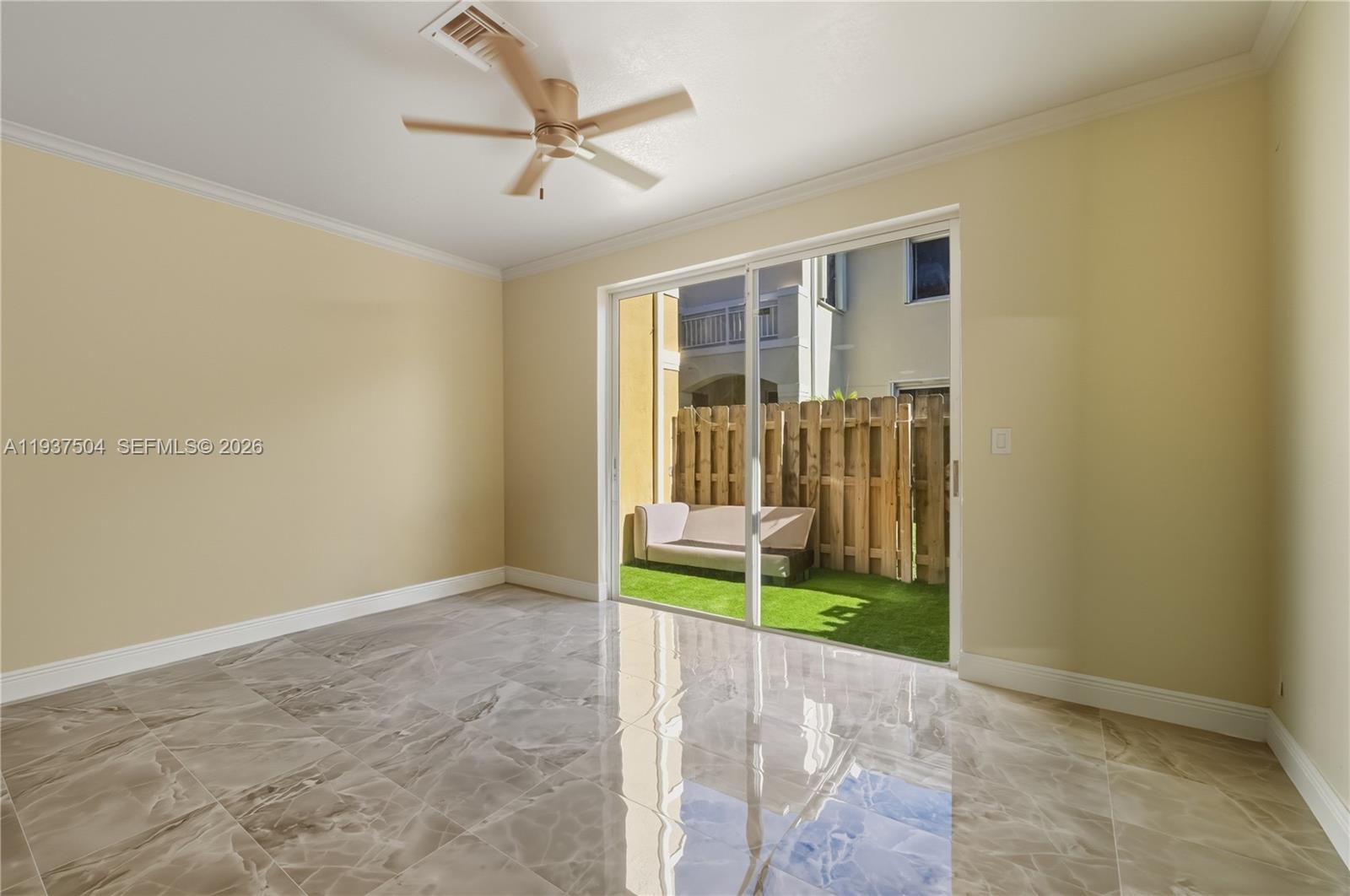 A room with glossy marble-style tile flooring, a ceiling fan, and sliding glass doors — 810 NE 212th Ter # 5, Miami FL 33179, MIAMI, FL