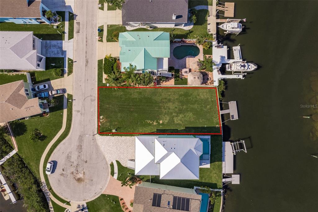 An aerial view shows a vacant waterfront residential lot outlined in red — 5627 JOBETH DRIVE, NEW PORT RICHEY, FL