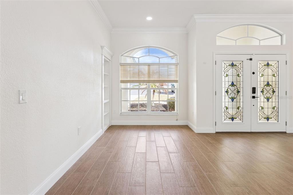 An entryway features wood-look tile flooring, a large arched window, and a decorative double door — 6410 BENDELOW DRIVE, LAKELAND, FL