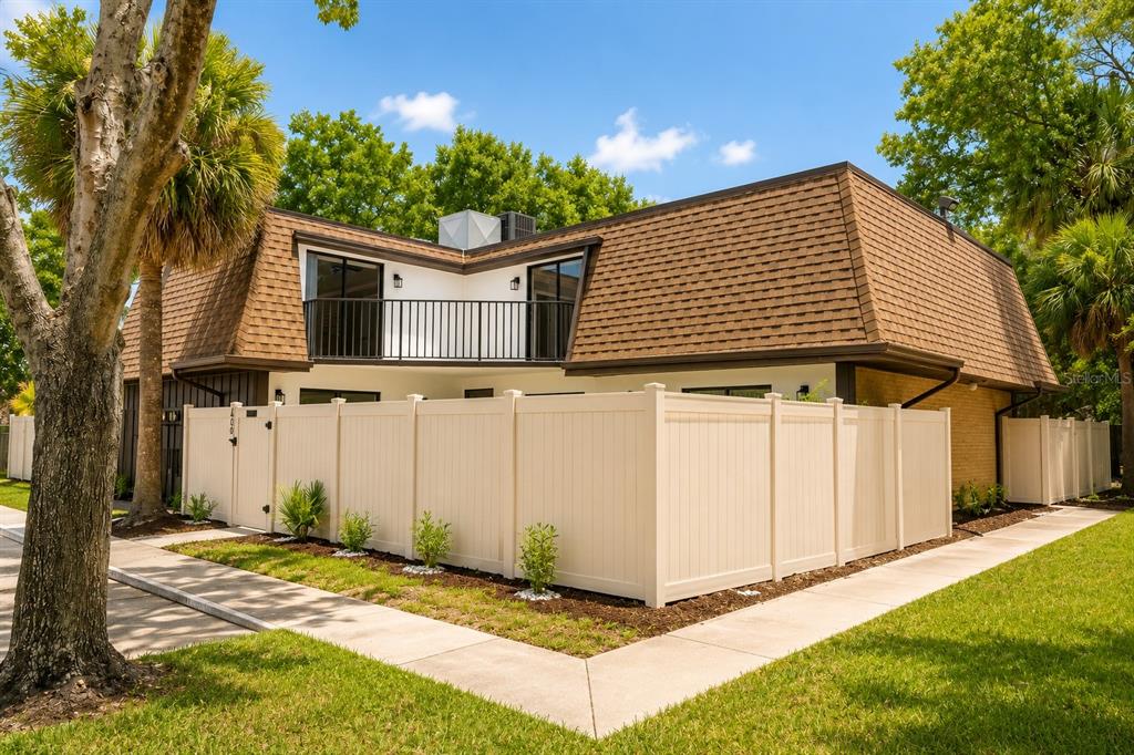 A two-story house with a brown mansard roof and a white privacy fence — 4030 SHANNON BROWN DRIVE, ORLANDO, FL