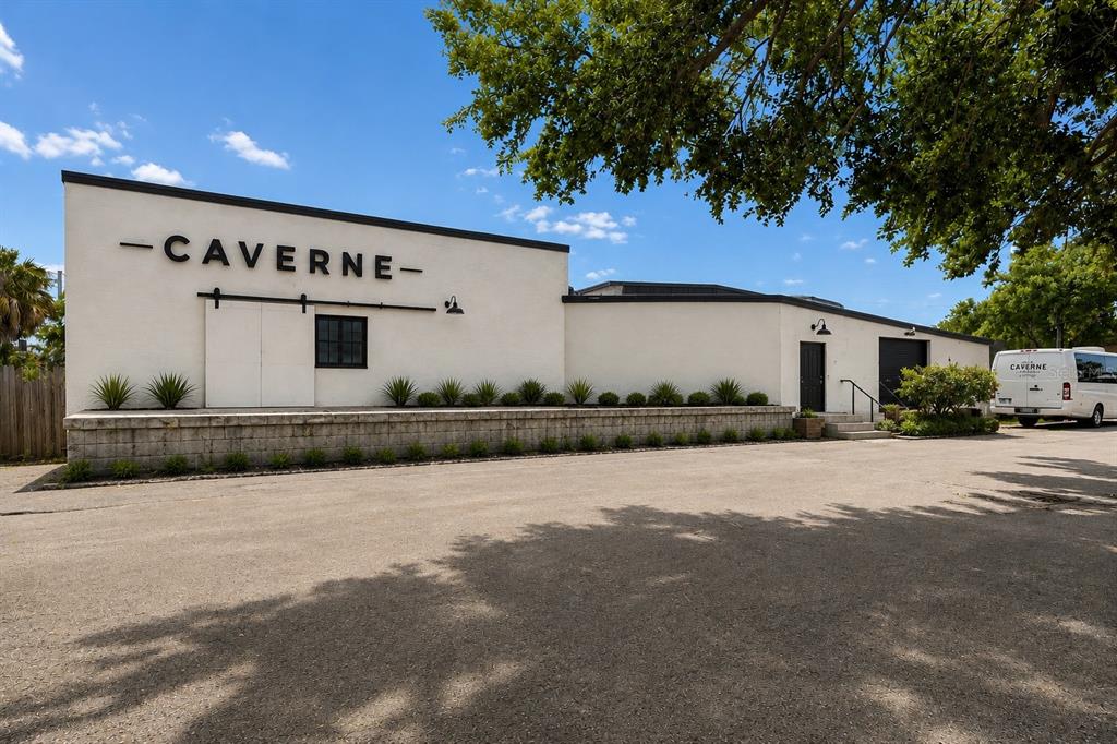 The exterior of a white commercial building features a loading dock and a large sign — 4214 W VIRGINIA AVE UNIT 11, TAMPA, FL