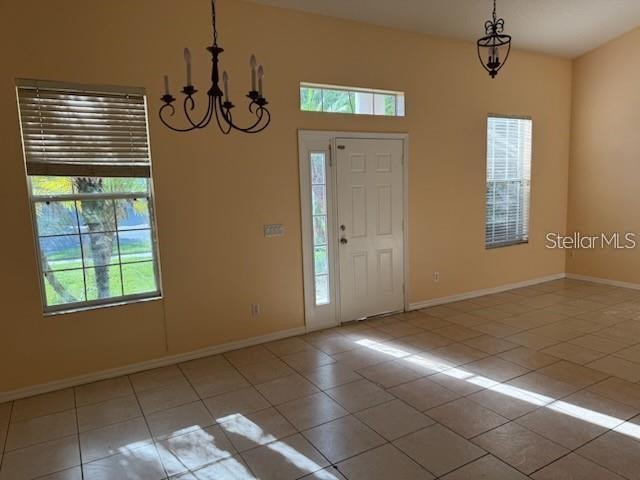 An entryway with tile flooring, two chandeliers, a front door, and two windows — 3321 PAWLEYS LOOP N, ST CLOUD, FL