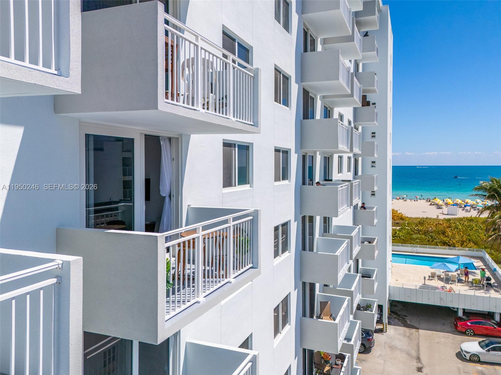 An exterior view of a white multi-story apartment building with balconies overlooking the beach — 345 Ocean Dr # 610, Miami Beach FL 33139, MIAMI BEACH, FL