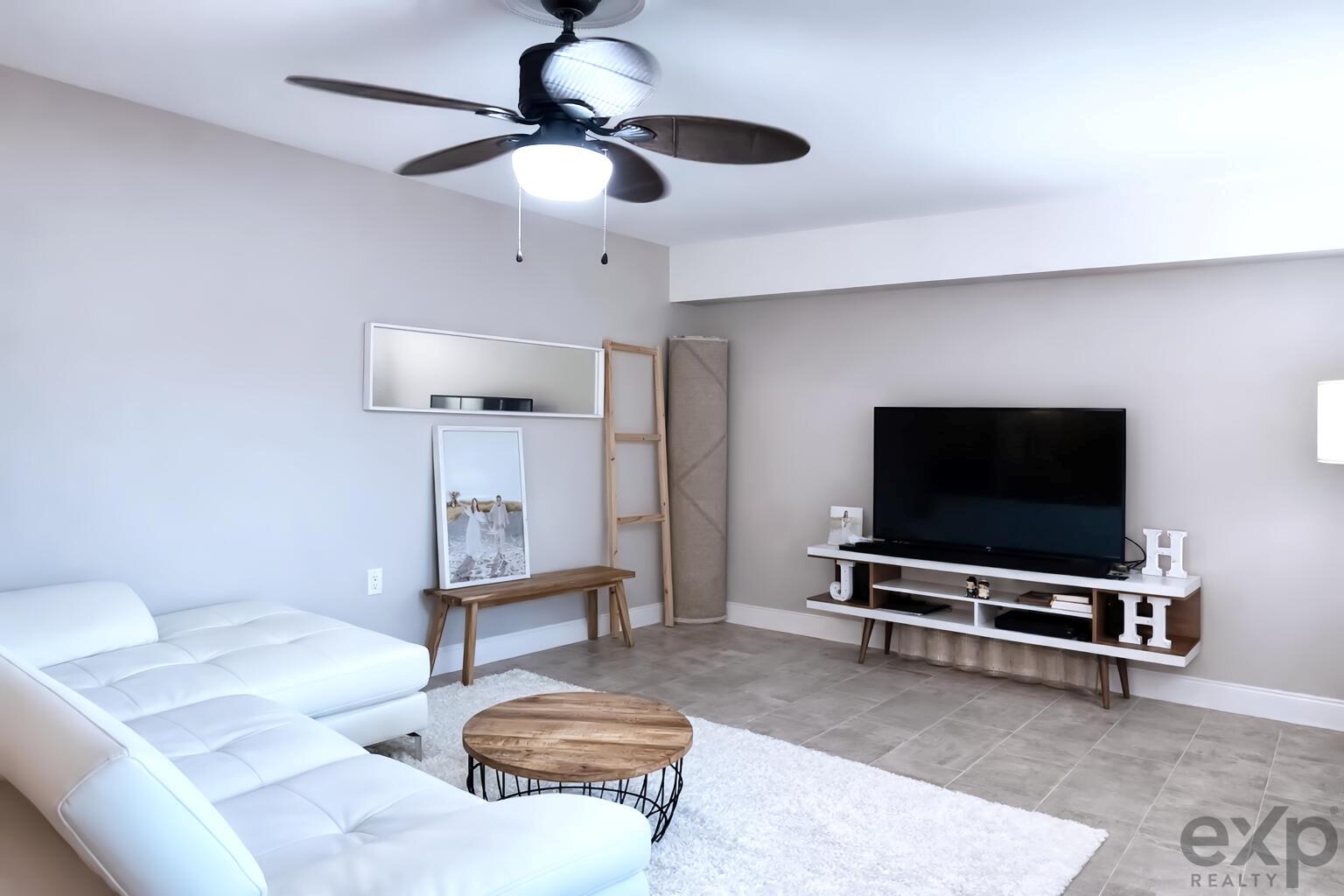 A living room features a white sectional sofa, a wooden coffee table, and a television console — 1008 10th Way, West Palm Beach FL 33407, WEST PALM BEACH, FL