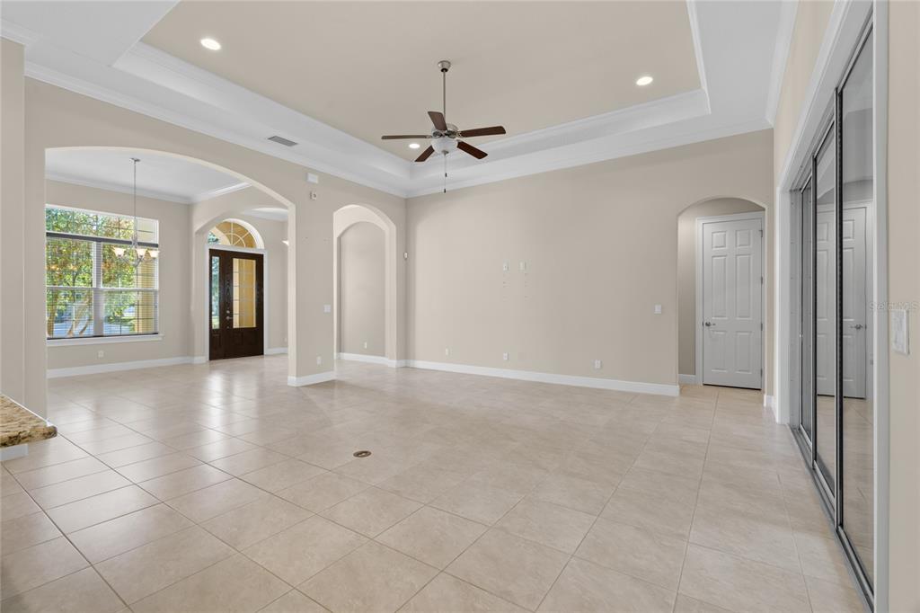 A spacious living room with tile floors, a tray ceiling, and a ceiling fan — 4117 SE 21ST STREET, OCALA, FL