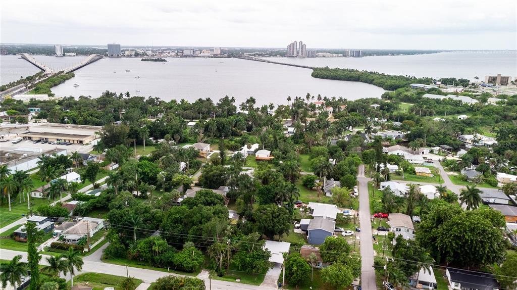 An aerial view shows a residential neighborhood with lush trees near a large bay — 57 CABANA AVENUE, NORTH FORT MYERS, FL
