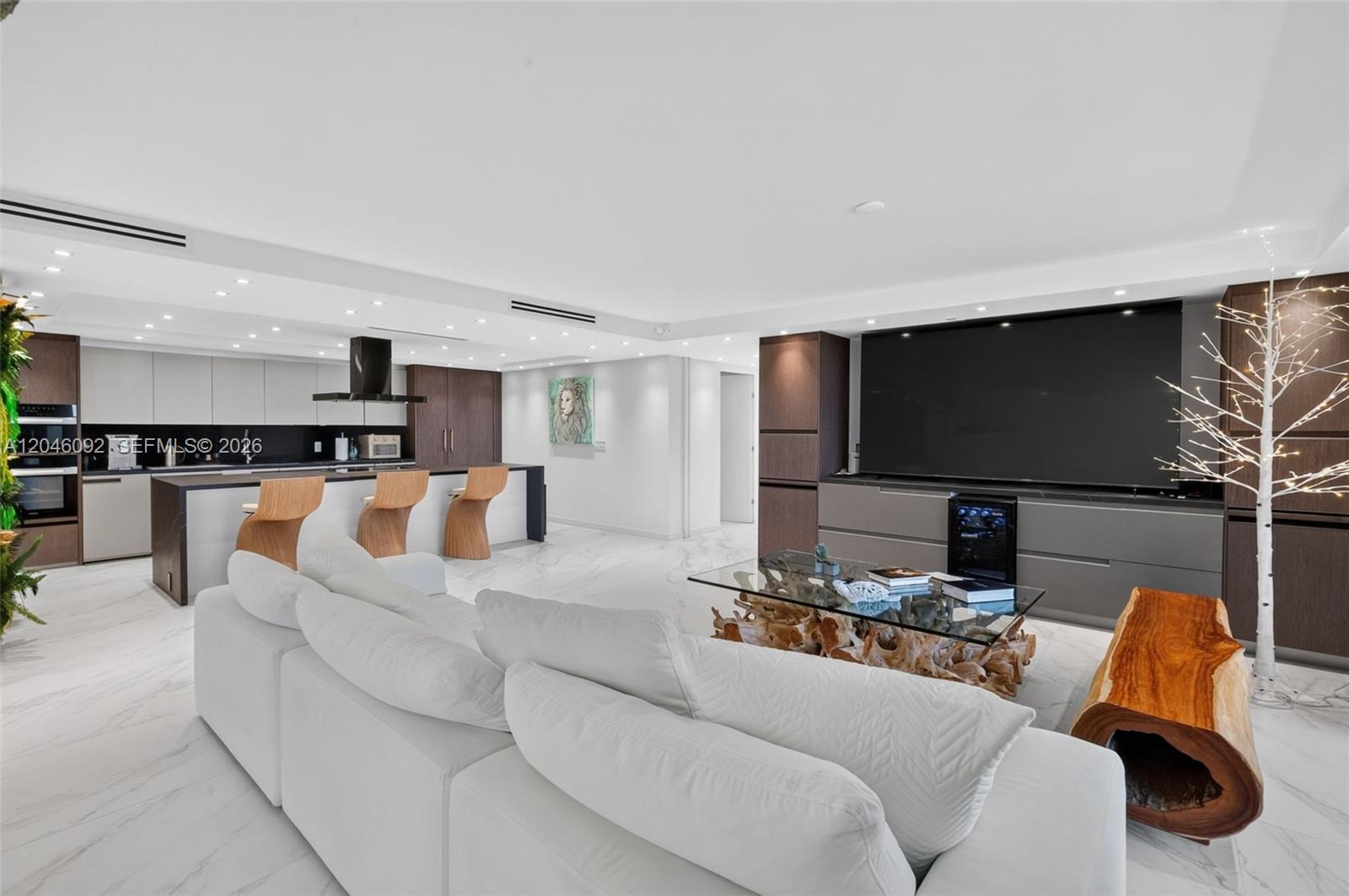 A modern open-concept living room features a white sofa, marble floors, and a kitchen island — 2301 Collins Ave # 443, Miami Beach FL 33139, MIAMI BEACH, FL