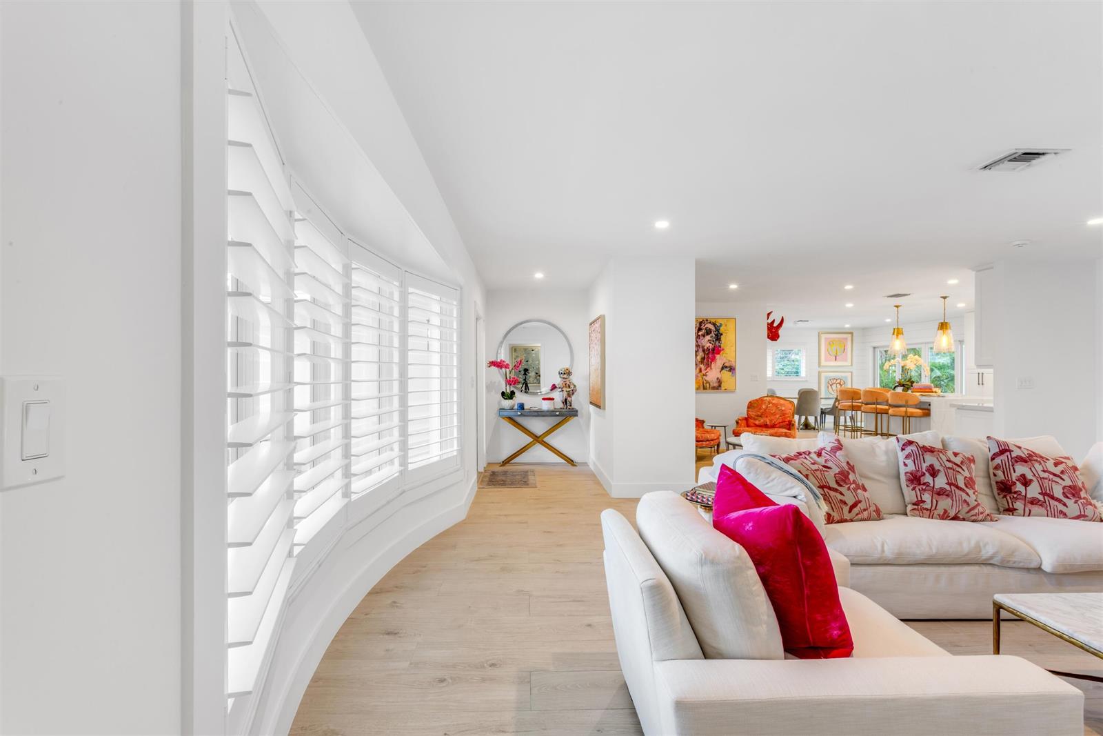 A bright living room features white walls, light wood flooring, and a curved window wall — 2720 Cardinal Circle, Gulf Stream FL 33483, GULF STREAM, FL