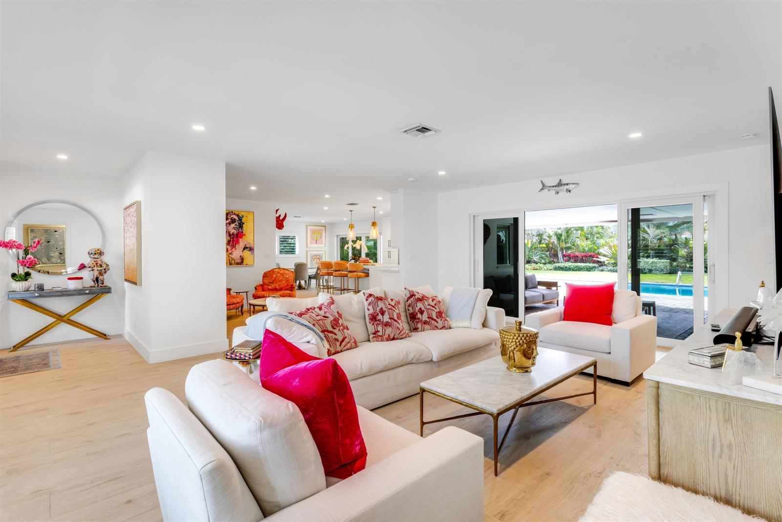A bright living room features white sofas, a marble coffee table, and sliding glass doors — 2720 Cardinal Circle, Gulf Stream FL 33483, GULF STREAM, FL