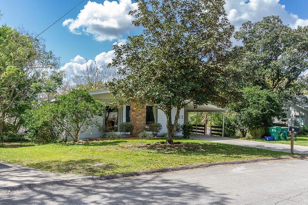 A single-story house with a brick facade, carport, and large tree in the front yard — 11 S UNIVERSITY CIRCLE, DELAND, FL