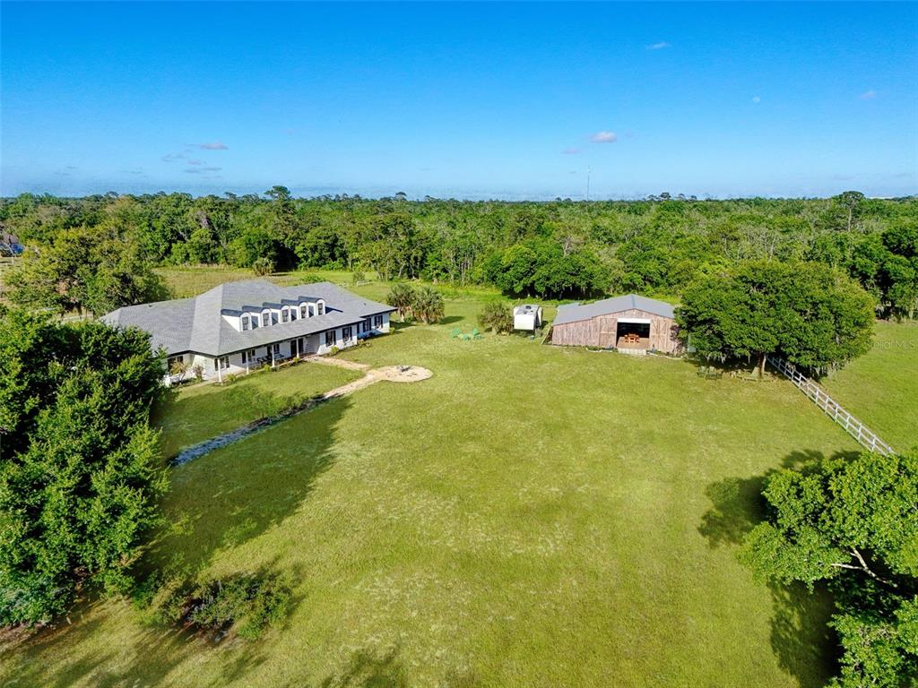 An aerial view shows a house and a barn on a large, grassy rural lot — 5750 OAK HOLLOW LANE, OVIEDO, FL