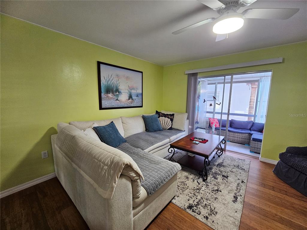 A living room features a sectional sofa, a coffee table, and a sliding glass door — 5896 PALM LANE UNIT C27, BRADENTON, FL