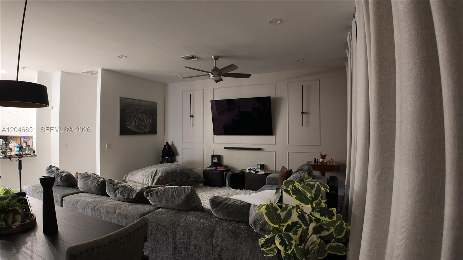 A living room features a large gray sectional sofa, a wall-mounted television, and decorative molding — 1831 SW 48th Ave, West Park FL 33023, WEST PARK, FL