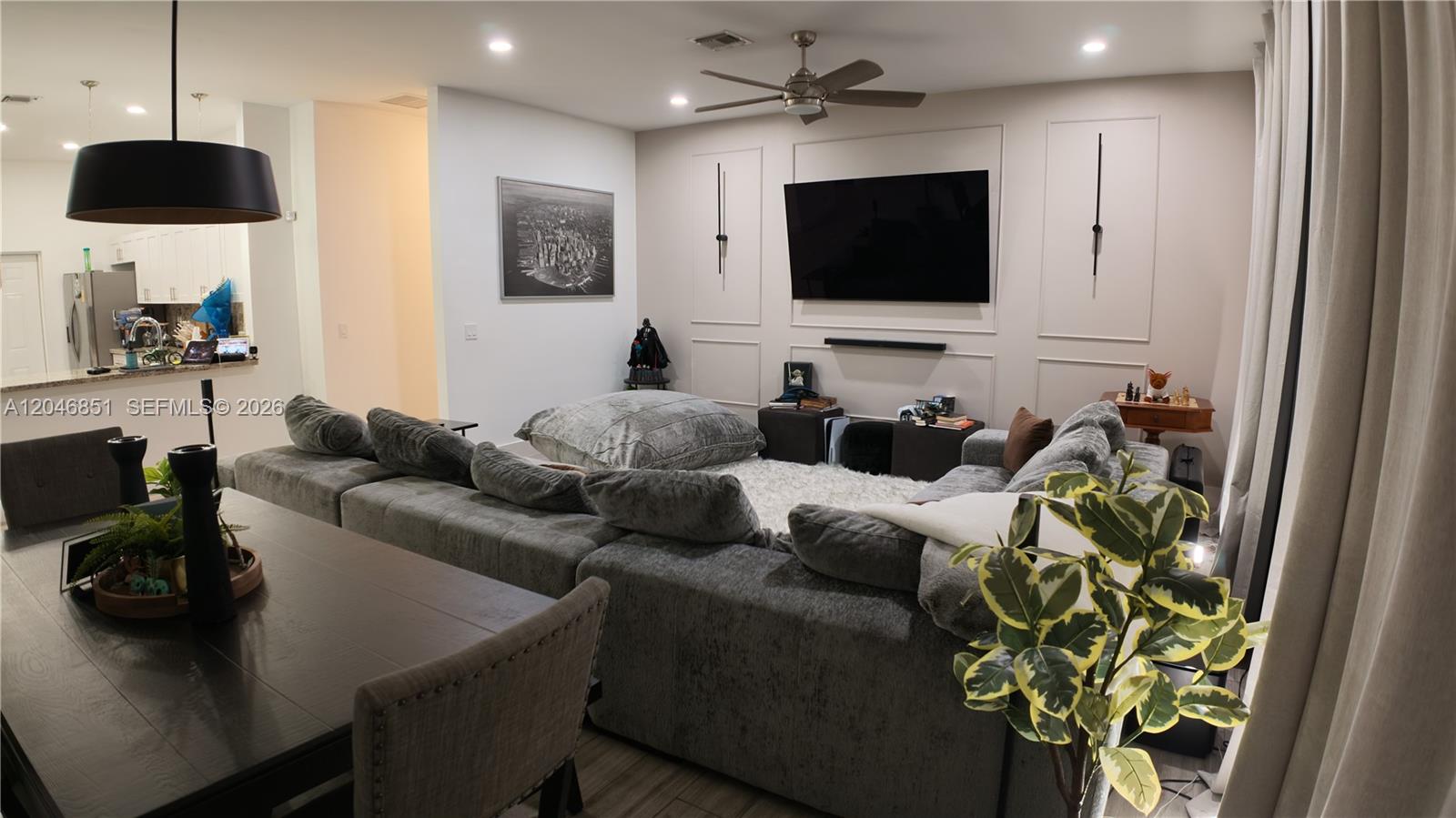 A living room features a large grey sectional sofa, a wall-mounted television, and dining furniture — 1831 SW 48th Ave, West Park FL 33023, WEST PARK, FL