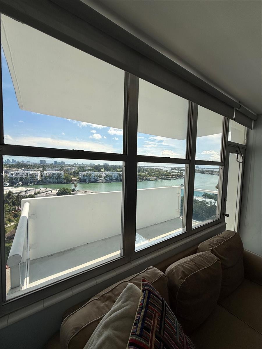 A view of a waterway and buildings from a room with large windows and seating — 7441 Wayne Ave # 10E, Miami Beach FL 33141, MIAMI BEACH, FL