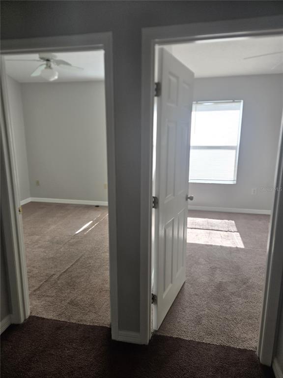 Two carpeted bedrooms are visible through open doorways in a hallway — 718 FLORIDA PALMS COURT, KISSIMMEE, FL