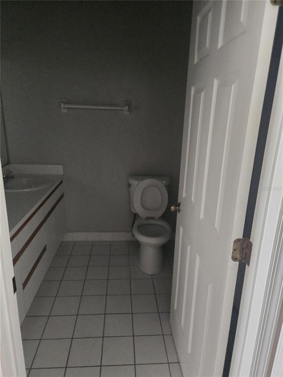 A bathroom features a white vanity, a toilet, and light-colored floor tiles — 718 FLORIDA PALMS COURT, KISSIMMEE, FL