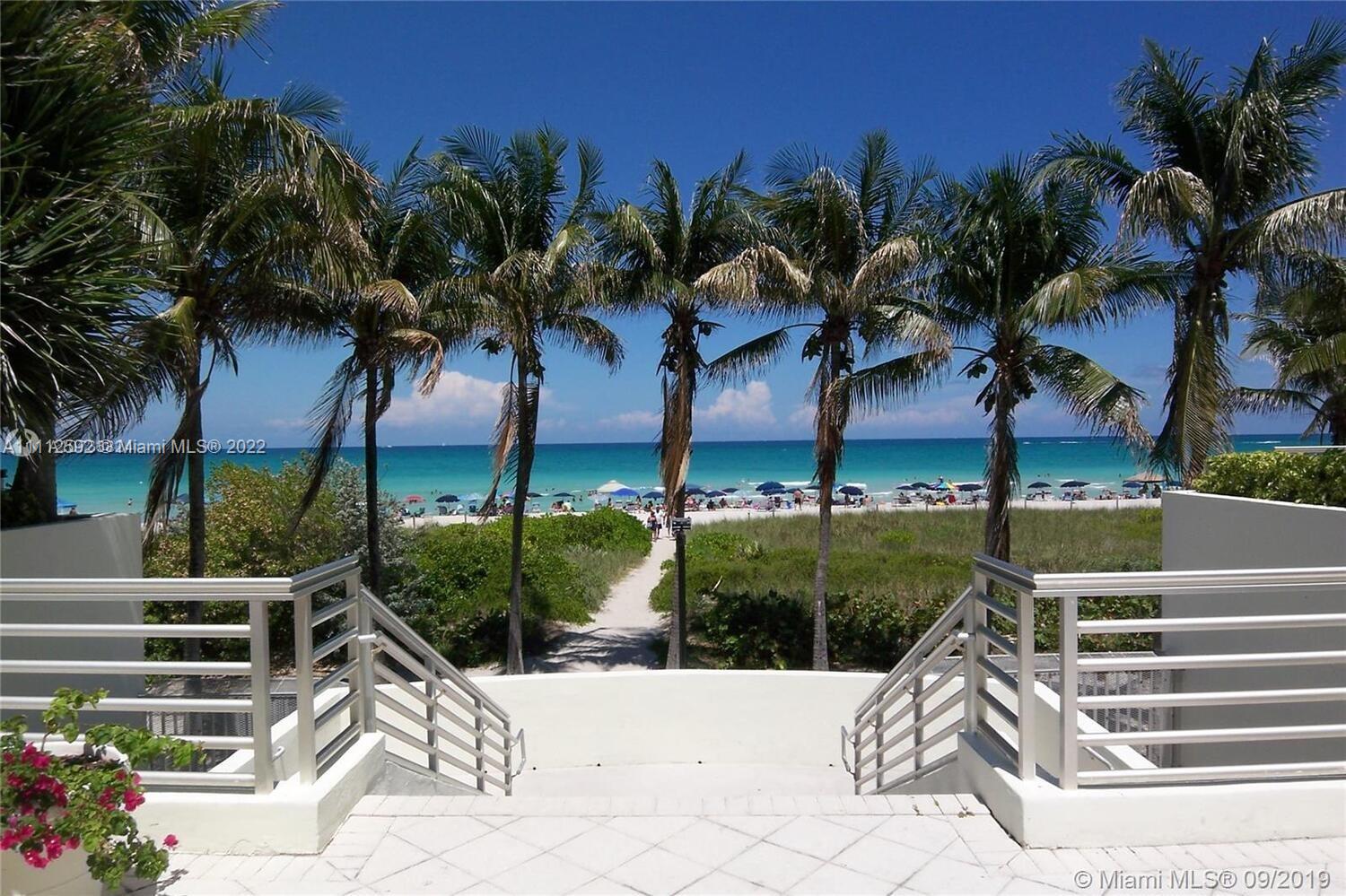 A concrete staircase leads down a path through palm trees toward a sunny beach — 5161 Collins Ave # 210, Miami Beach FL 33140, MIAMI BEACH, FL