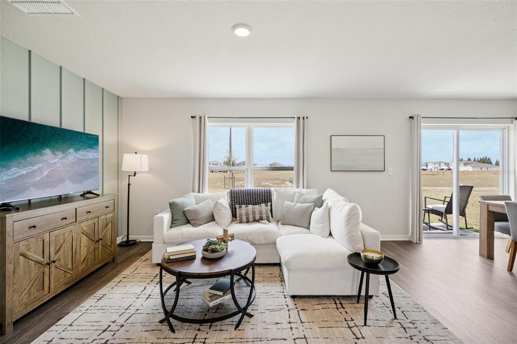 A living room features a white sectional sofa, a wooden media console, and a rug — 4410 BLACKWELL AVENUE, LAKE WALES, FL