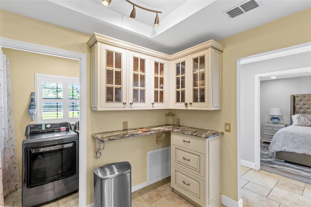 A laundry room area features cream cabinets, a stone countertop, and a stainless steel washer — 924 VIRGINIA AVENUE, ST CLOUD, FL