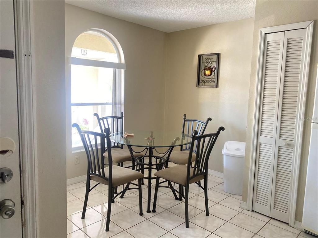 A dining area features a glass-topped table with four chairs, tile flooring, and an arched window — 3204 SABAL PALMS COURT UNIT B, KISSIMMEE, FL
