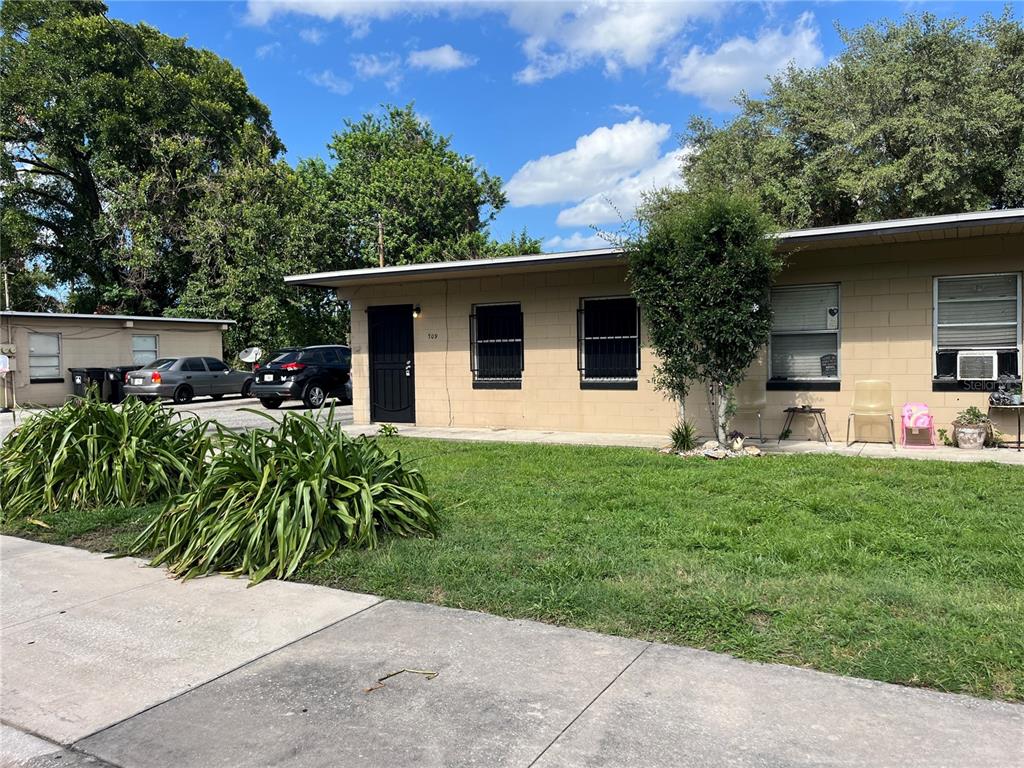 A single-story tan concrete block building with a black door and window security bars — 709 BOSTON AVENUE, ORLANDO, FL