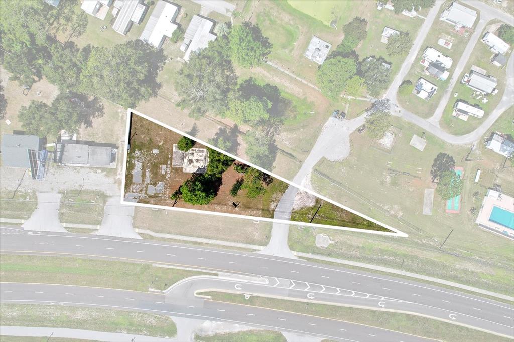 An aerial view shows a triangular-shaped vacant lot located next to a multi-lane highway — 15541 CORTEZ BOULEVARD, BROOKSVILLE, FL
